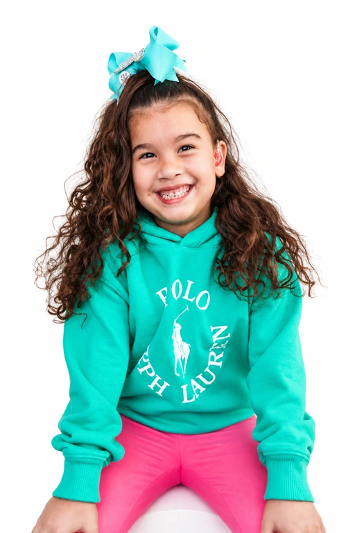Kathleen smiling in a turquoise bow and sweatshirt.